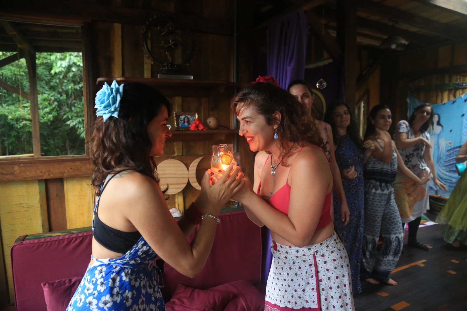 Mulheres em rito de passagem com vela acesa